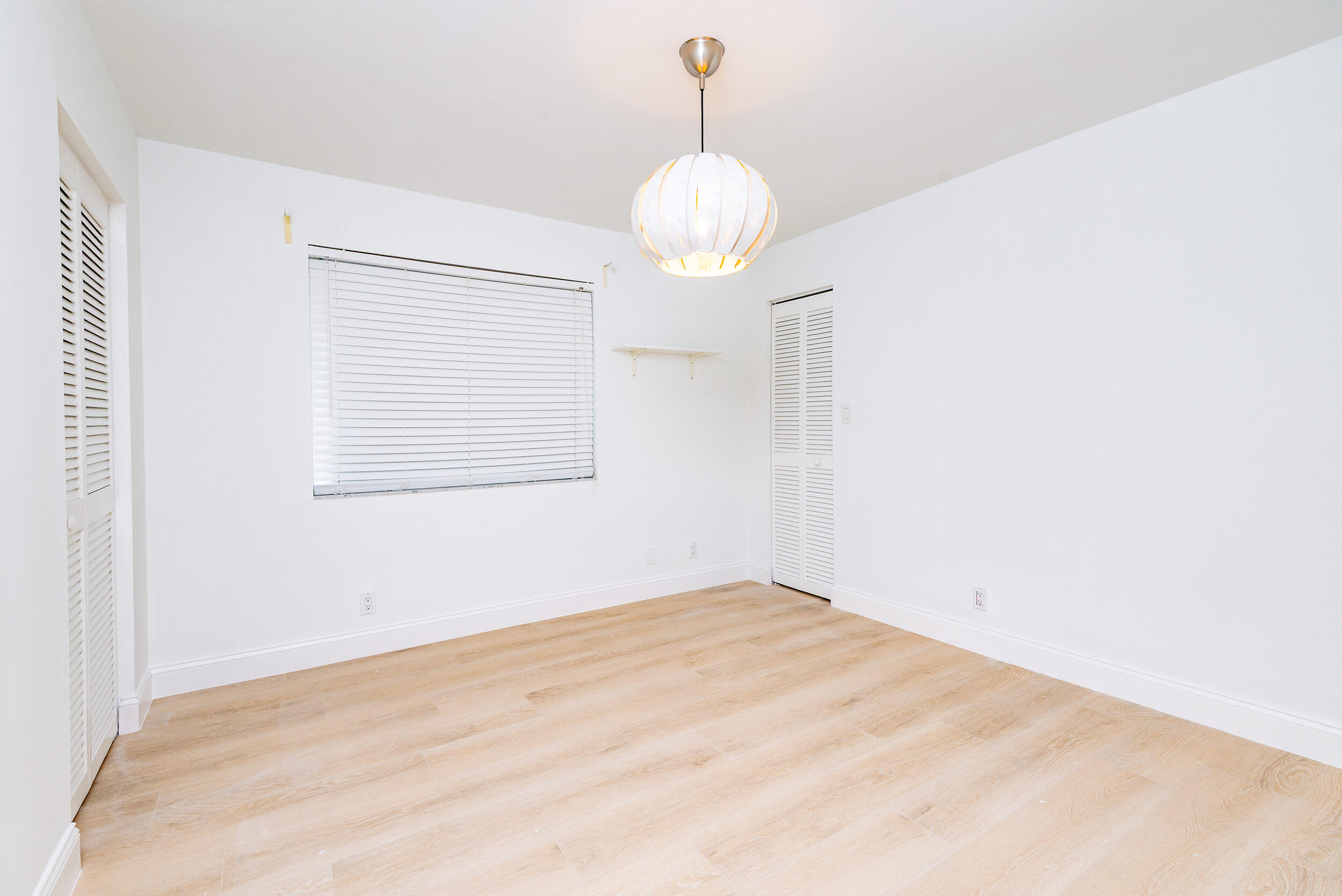 380 Northwest 67th Street, Unit J204 Boca Raton, FL 33487 - Photo 20 of 43 a view of a room with a chandelier fan and wooden floor