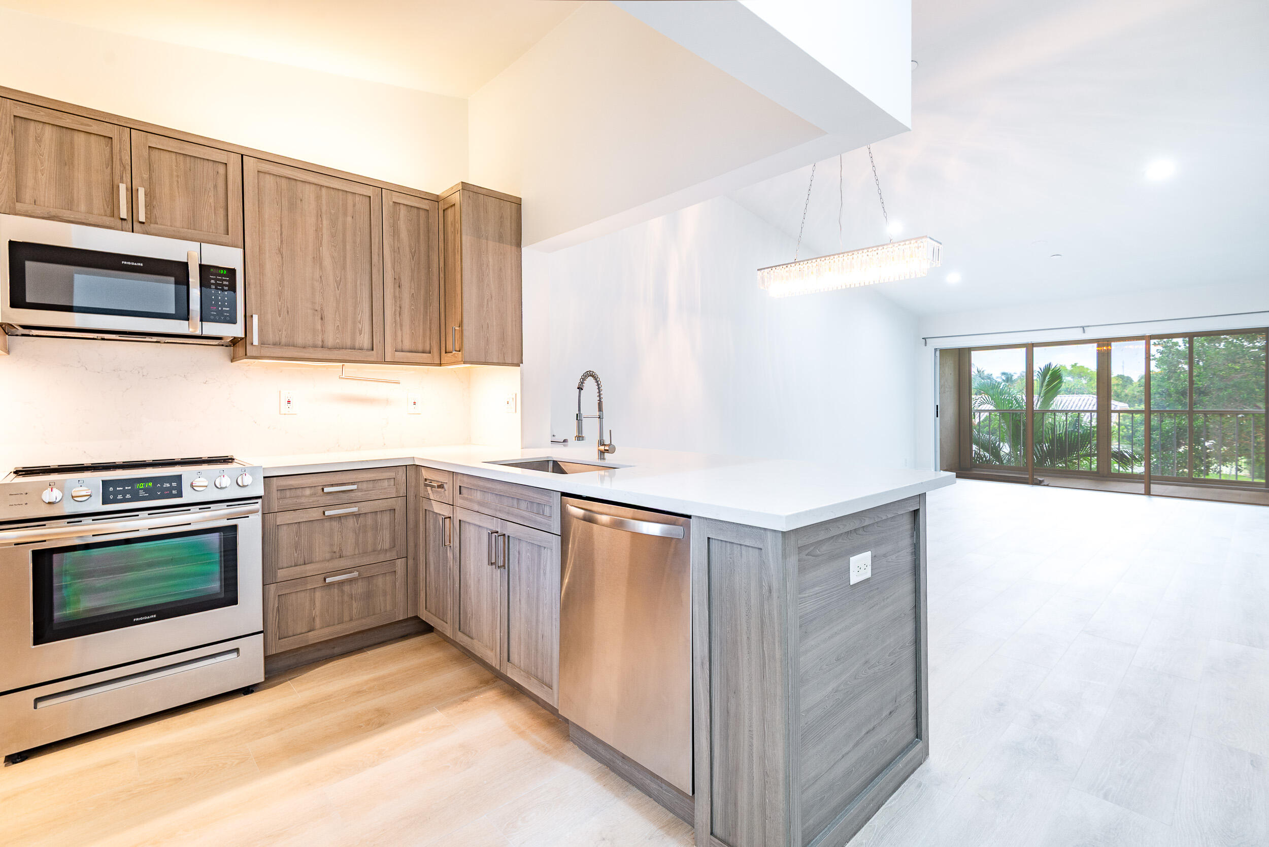 380 Northwest 67th Street, Unit J204 Boca Raton, FL 33487 - Photo 5 of 43 a kitchen with stainless steel appliances granite countertop a stove a microwave and a sink