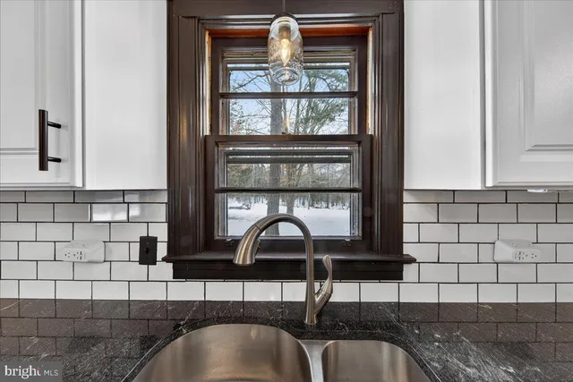a living room with furniture a flat screen tv and a floor to ceiling window