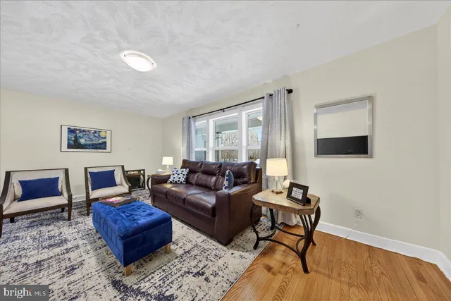 a living room with furniture a flat screen tv and kitchen view