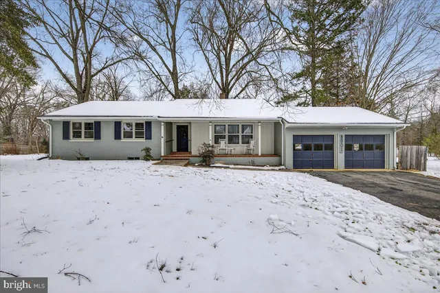 a front view of a house with yard and trees around