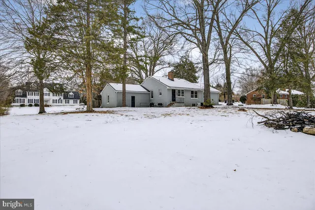 a view of a white house with a yard covered in snow