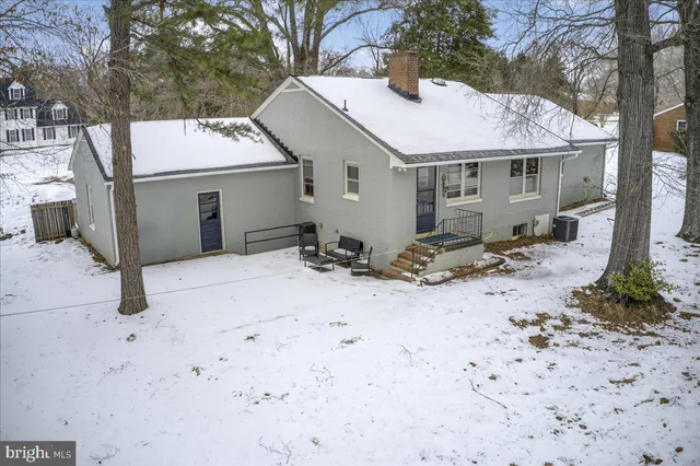 a white house with a large tree in front of it