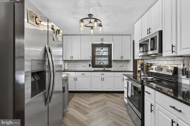 a kitchen with a refrigerator cabinets and wooden floor
