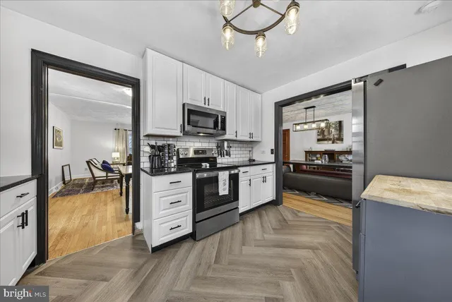 a kitchen with granite countertop white cabinets and stainless steel appliances