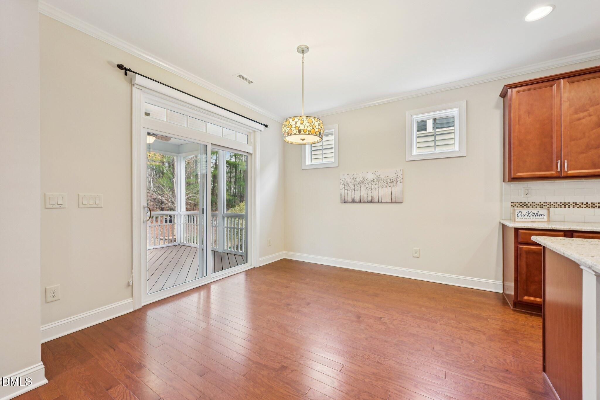 316 Rapport Drive Cary, NC 27519 - Photo 11 of 60 a view of an empty room with a window and wooden floor