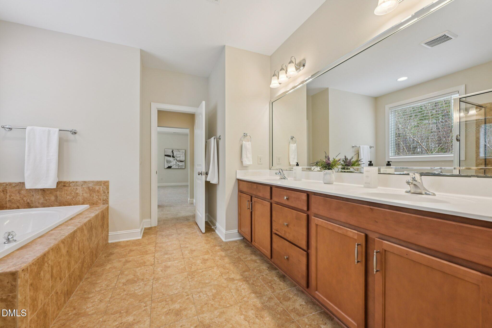 316 Rapport Drive Cary, NC 27519 - Photo 33 of 60 a spacious bathroom with a sink double vanity and a mirror