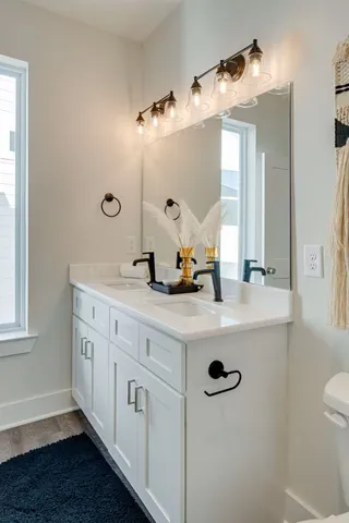a bathroom with a double vanity sink a mirror a vanity and window