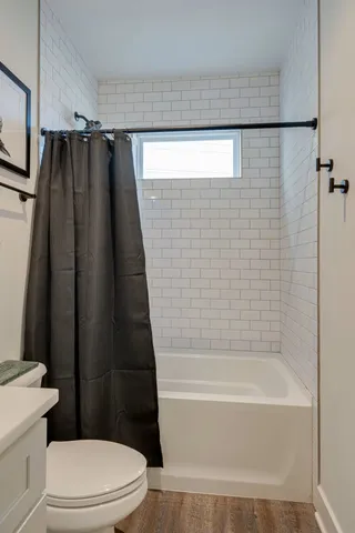 a bathroom with a shower a toilet and a bathtub