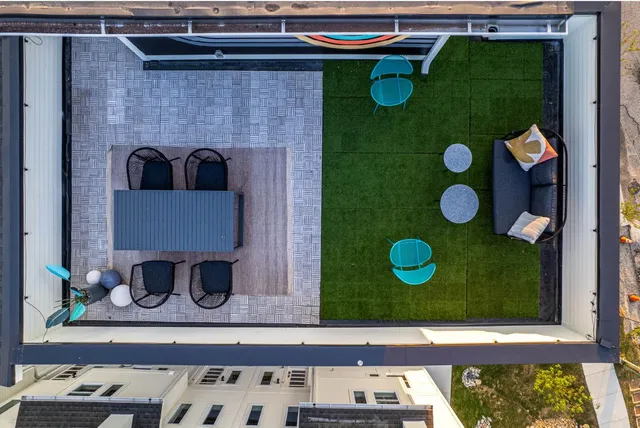 a roof deck with couches and wooden floor