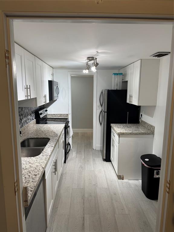 4174 Inverrary Drive, Unit 401 Lauderhill, FL 33319 - Photo 7 of 15 a kitchen with a sink stove and refrigerator
