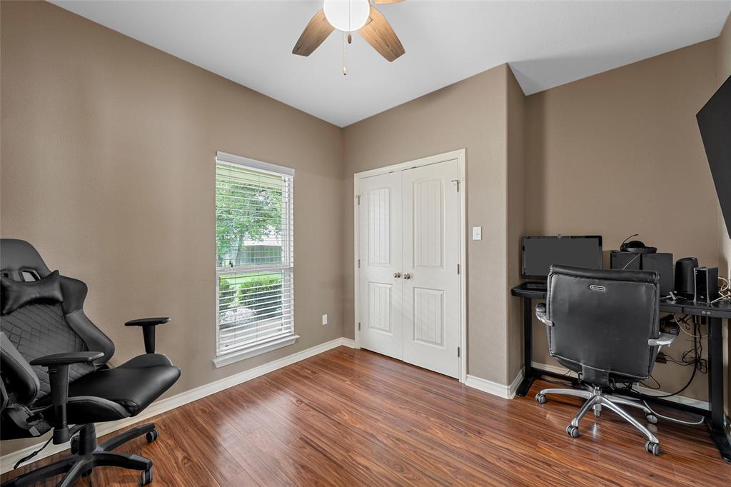 1117 Downsville Road Robinson, TX 76706 - Photo 16 of 40 Interior room featuring wood-finish flooring, a window with blinds, and white bi-fold doors