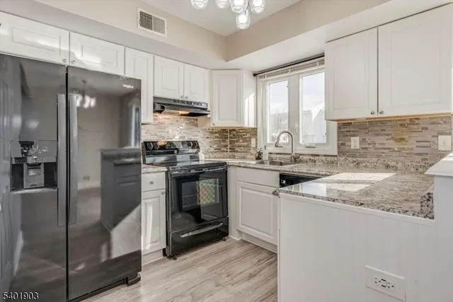 a kitchen with stainless steel appliances granite countertop a sink stove and cabinets