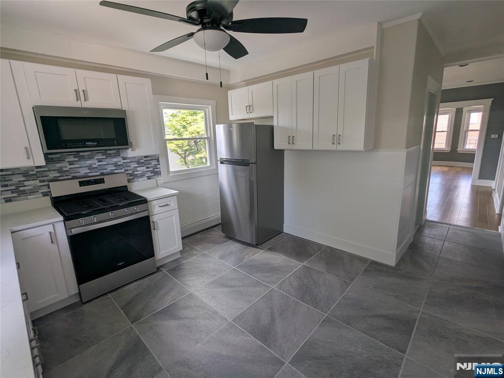 a kitchen with stainless steel appliances granite countertop a refrigerator a stove a microwave oven a sink with island and chairs