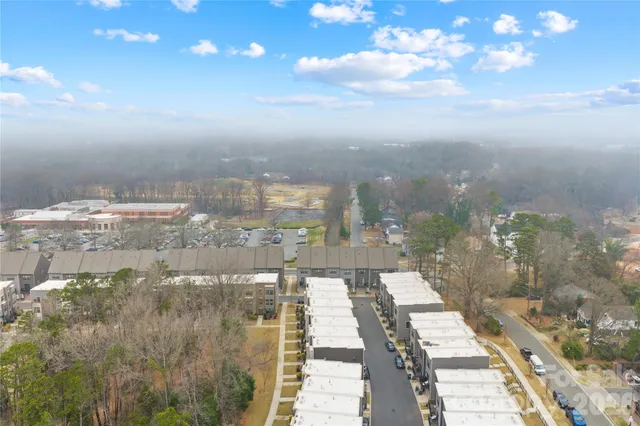 a open kitchen with stainless steel appliances granite countertop a refrigerator a sink a stove and white cabinets with wooden floor