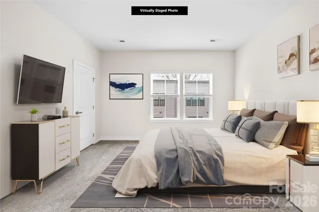 a bedroom with a large bed and a flat tv screen on dresser