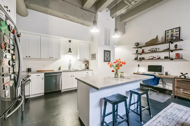 a kitchen with stainless steel appliances granite countertop a sink a stove and white cabinets