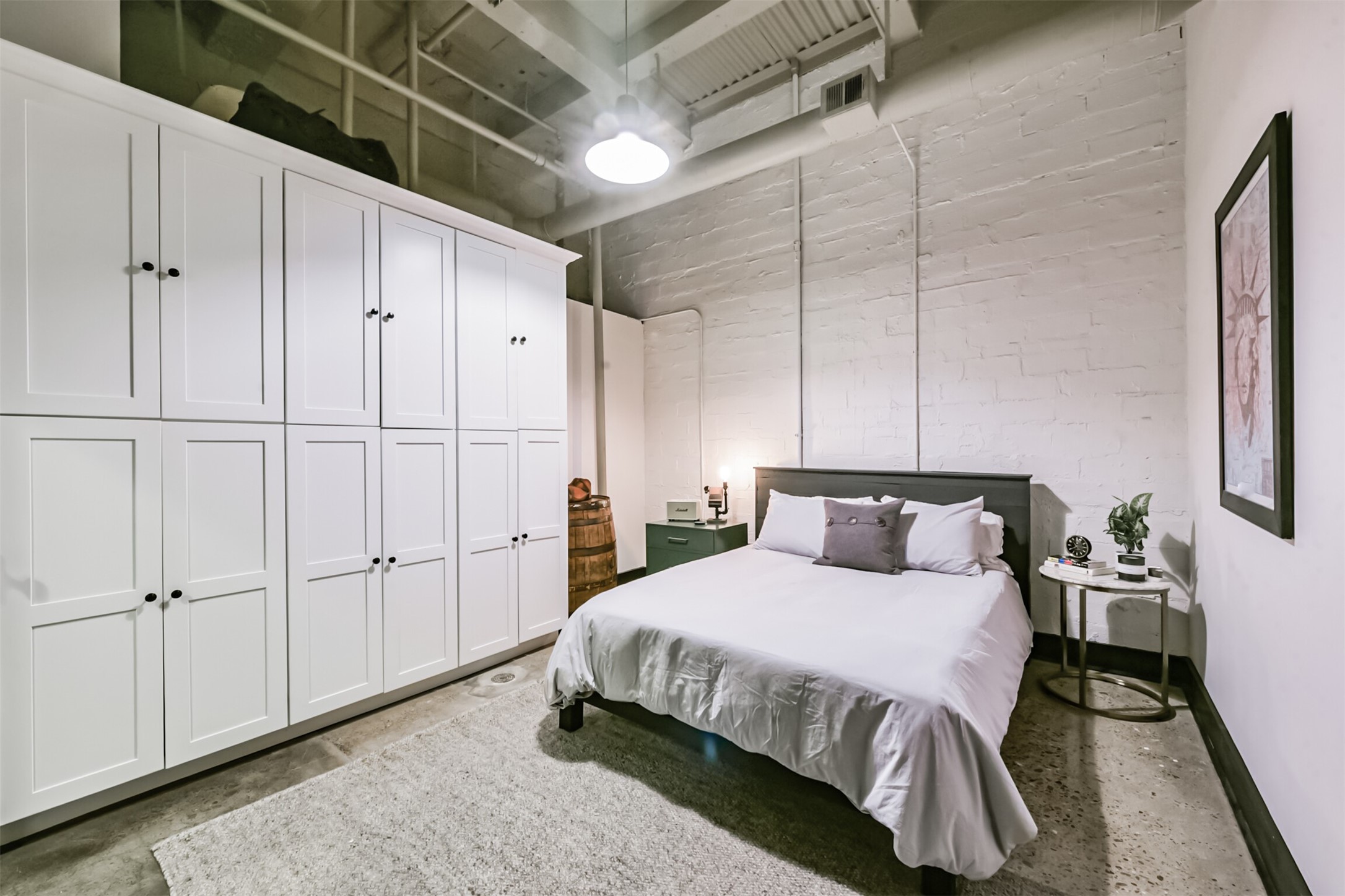 705 Main Street, Unit 321 Houston, TX 77002 - Photo 9 of 39 a spacious bedroom with a bed a table and painting on the wall