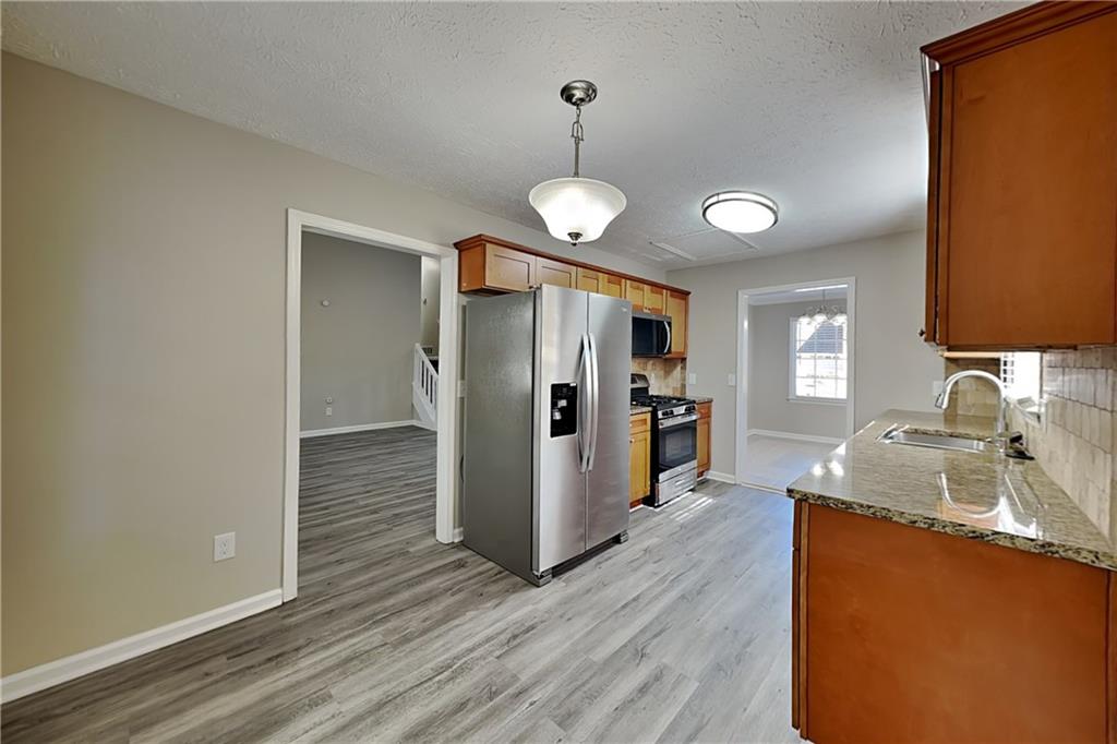 3094 Calumet Circle Northwest Kennesaw, GA 30152 - Photo 5 of 23 a kitchen with stainless steel appliances granite countertop a sink refrigerator and stove