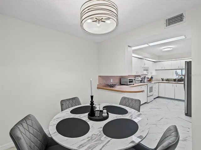 a kitchen with a sink chairs and a dining table