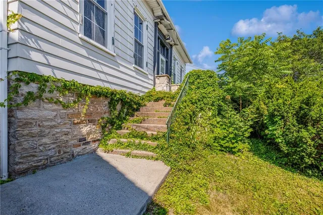 a view of a house with a yard and potted plants