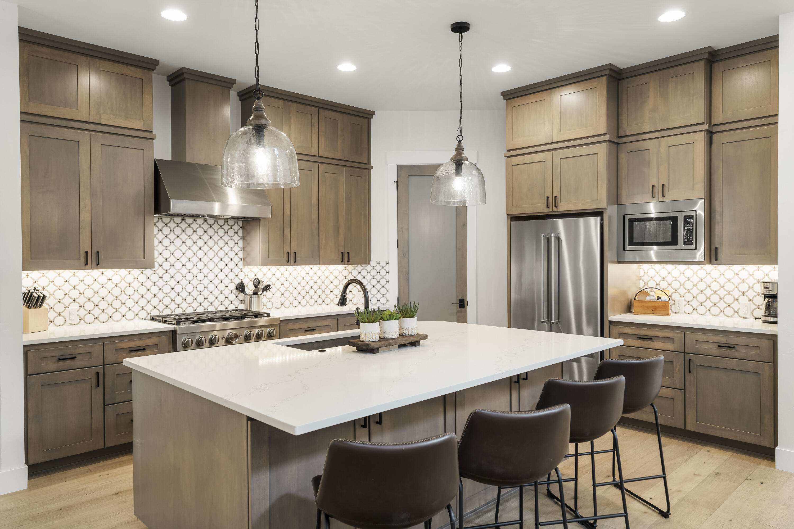 56302 Sable Rock Loop, Unit 255 Bend, OR 97707 - Photo 15 of 65 a kitchen with stainless steel appliances a dining table chairs sink and cabinets