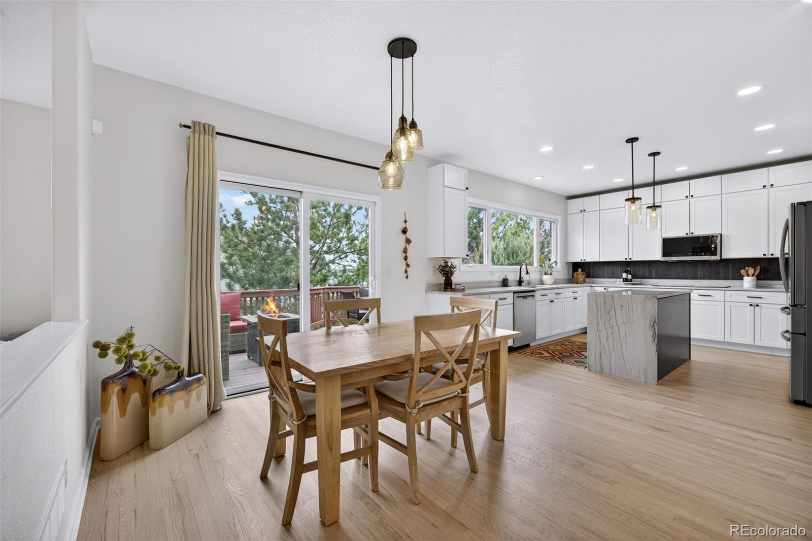 551 Seth Place Castle Pines, CO 80108 - Photo 13 of 50 a view of a dining room with furniture window and wooden floor