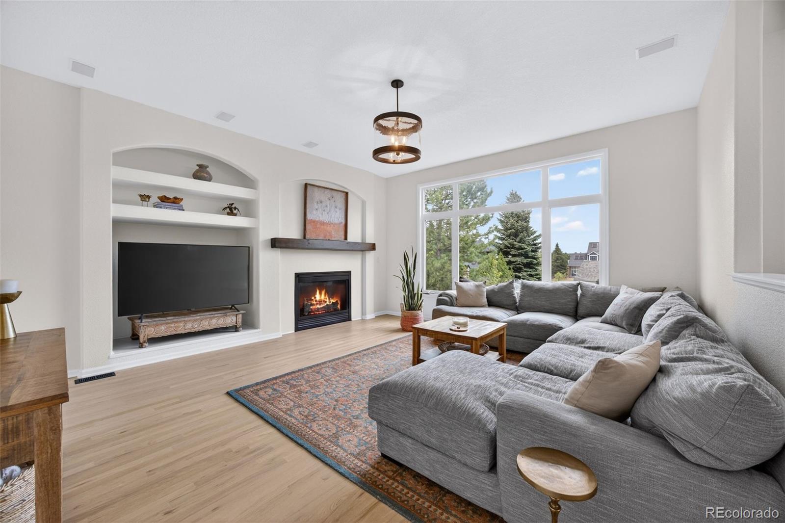 551 Seth Place Castle Pines, CO 80108 - Photo 14 of 50 a living room with furniture a fireplace and a window
