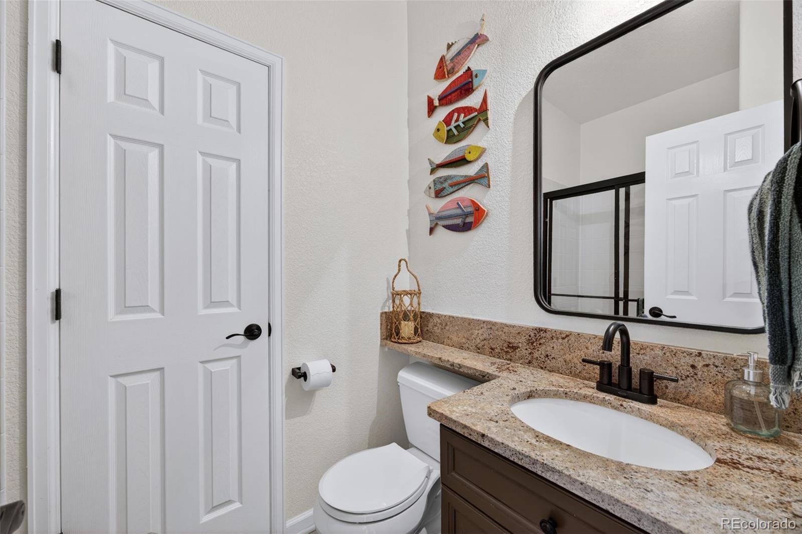 551 Seth Place Castle Pines, CO 80108 - Photo 19 of 50 a bathroom with a granite countertop sink and a mirror