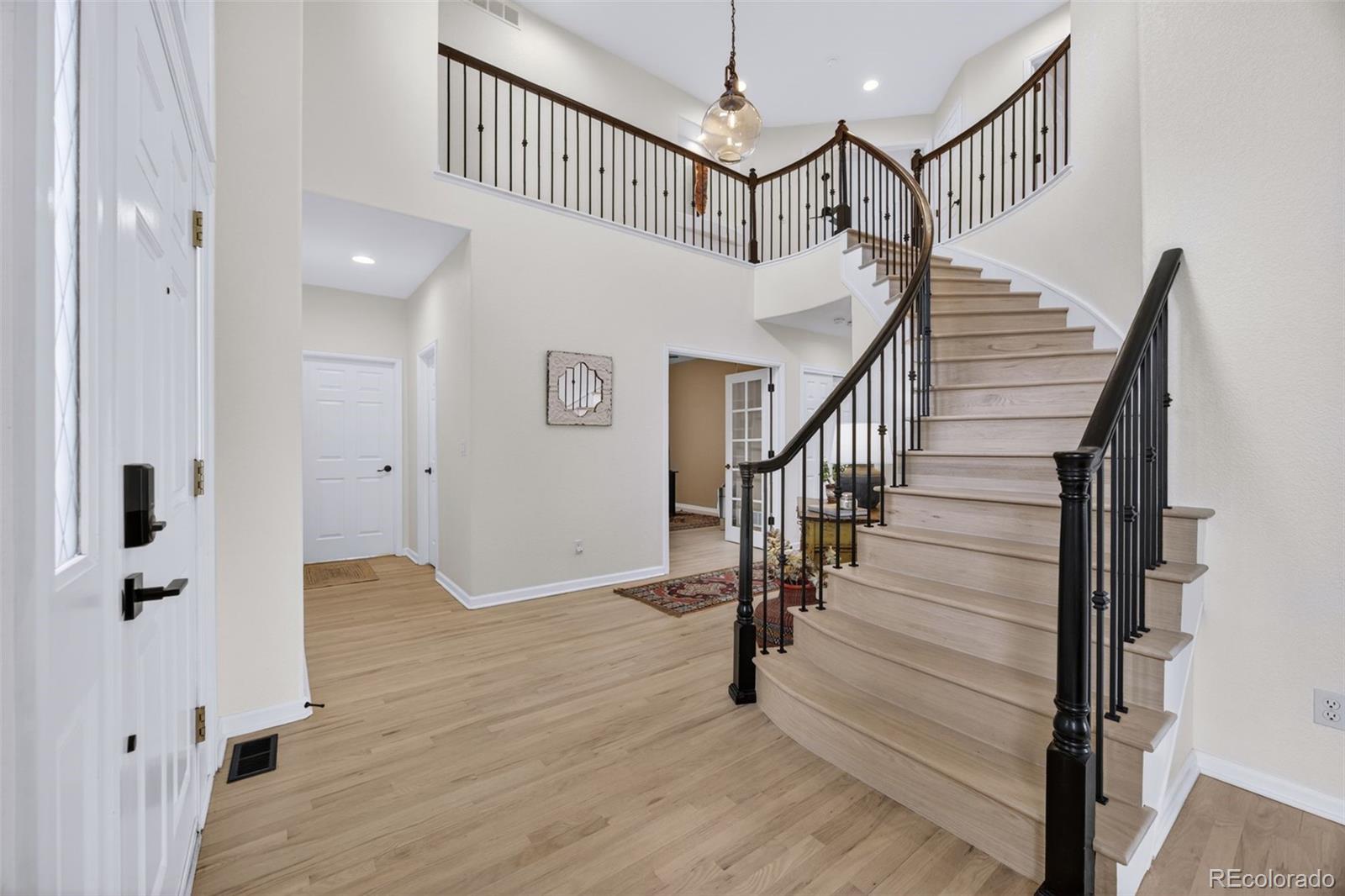 551 Seth Place Castle Pines, CO 80108 - Photo 21 of 50 a view of entryway with wooden floor and stairs