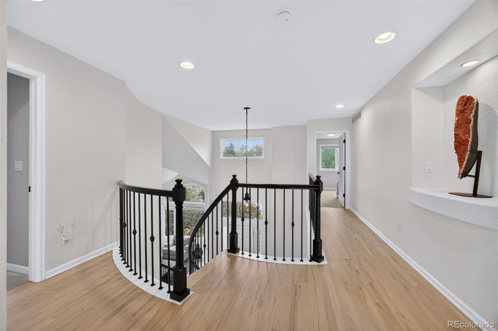 551 Seth Place Castle Pines, CO 80108 - Photo 22 of 50 a view of a hallway with wooden floor and windows