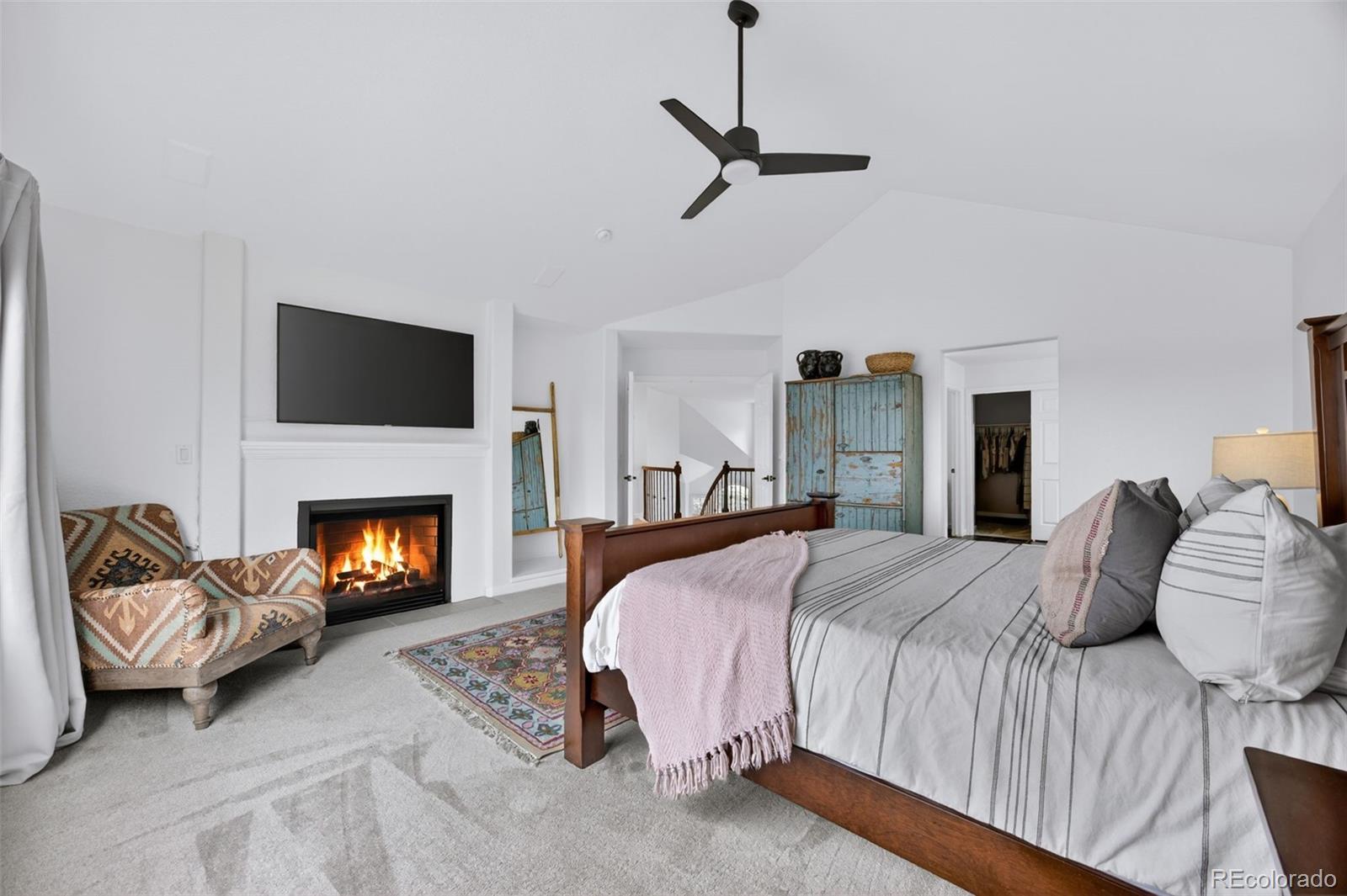 551 Seth Place Castle Pines, CO 80108 - Photo 24 of 50 a bedroom with a bed and a fireplace