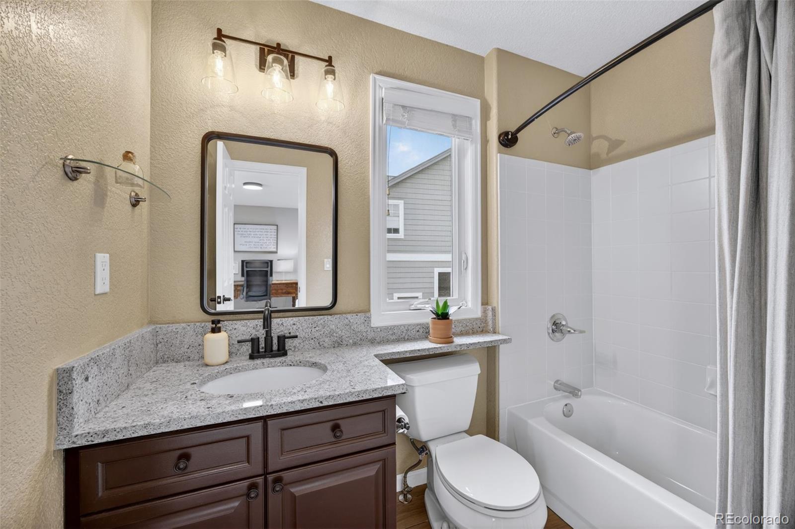 551 Seth Place Castle Pines, CO 80108 - Photo 28 of 50 a bathroom with a granite countertop sink toilet and shower