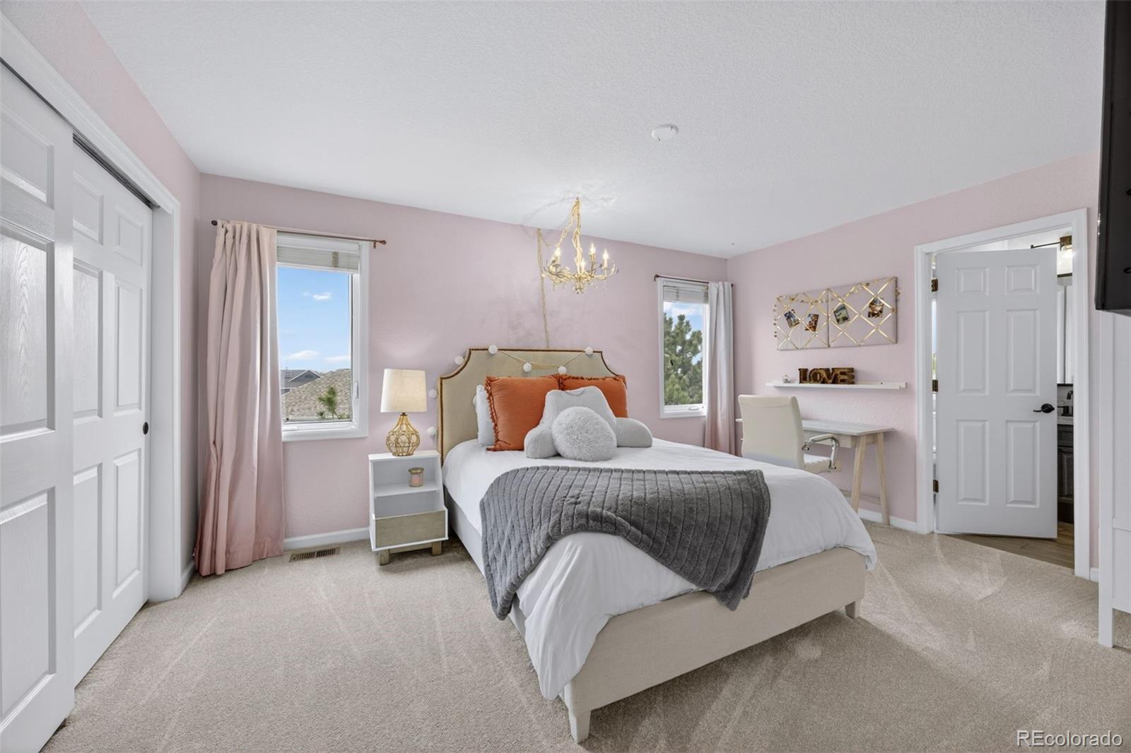 551 Seth Place Castle Pines, CO 80108 - Photo 29 of 50 a bedroom with a bed and a chandelier