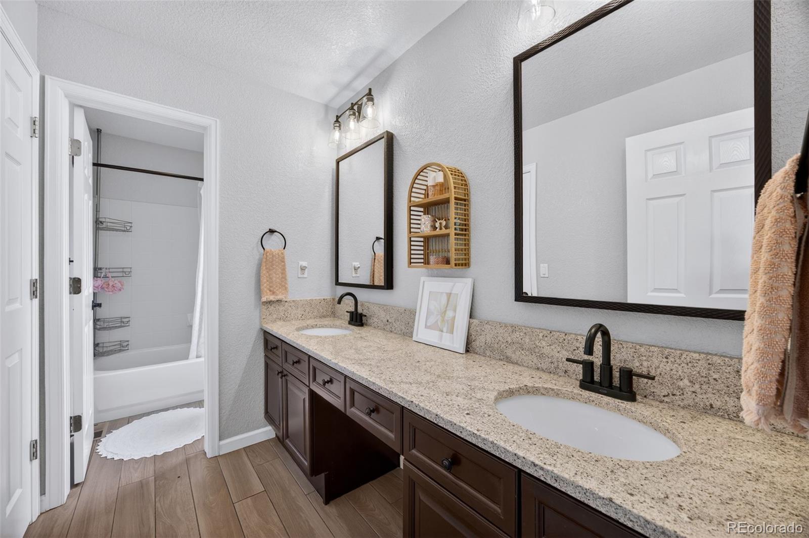 551 Seth Place Castle Pines, CO 80108 - Photo 30 of 50 a bathroom with a granite countertop double vanity sink and a mirror