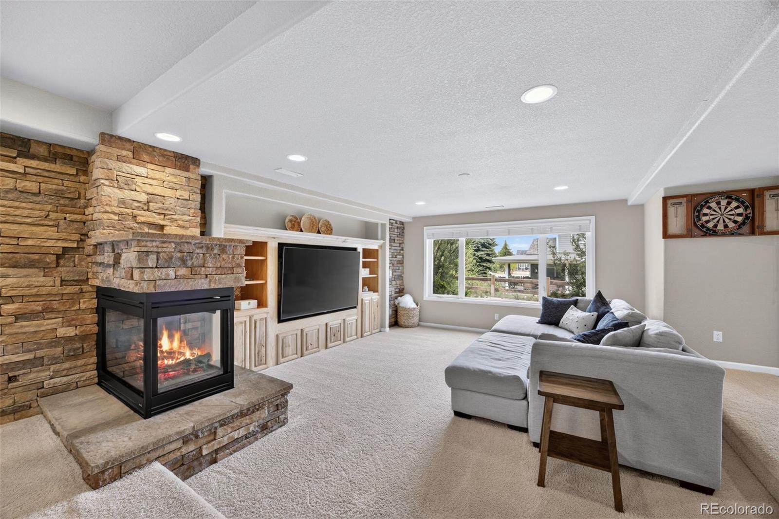 551 Seth Place Castle Pines, CO 80108 - Photo 35 of 50 a living room with furniture a flat screen tv and a fireplace