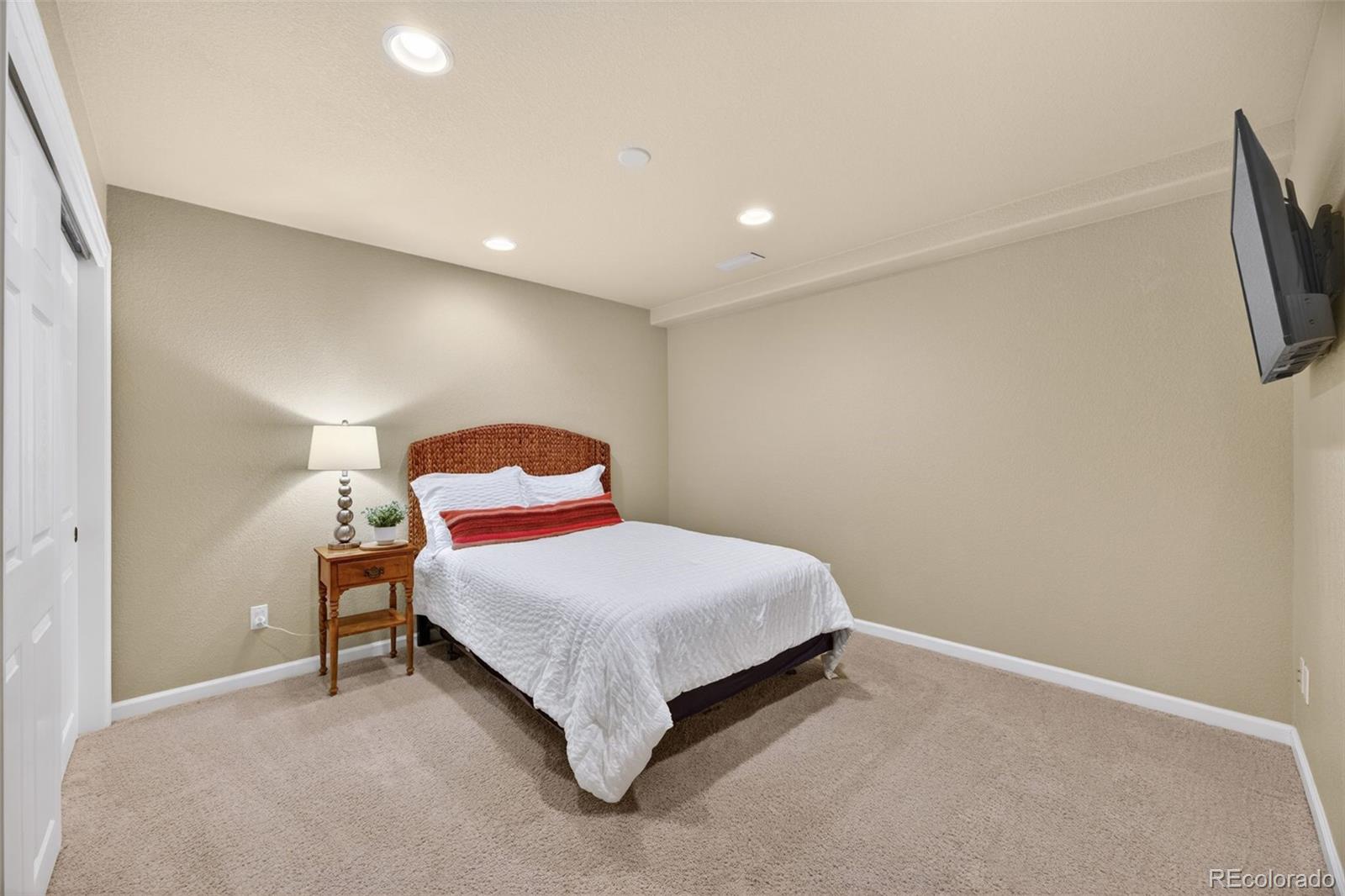 551 Seth Place Castle Pines, CO 80108 - Photo 39 of 50 a bedroom with a bed and a lamp on dresser