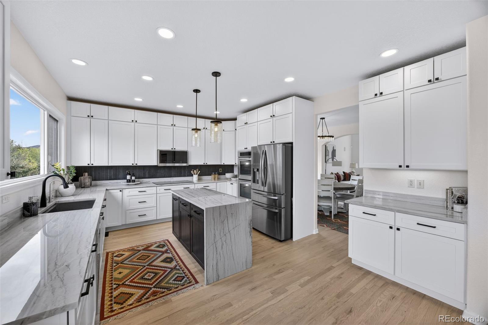 551 Seth Place Castle Pines, CO 80108 - Photo 6 of 50 a kitchen with a refrigerator a sink and cabinets