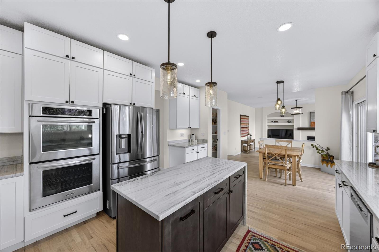 551 Seth Place Castle Pines, CO 80108 - Photo 7 of 50 a kitchen with a center island and stainless steel appliances