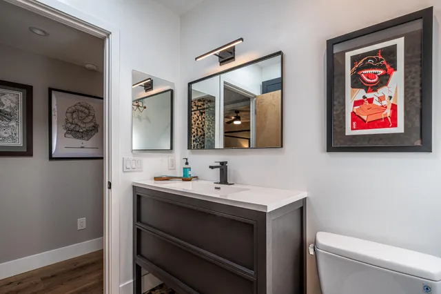 a living room with stainless steel appliances furniture a dining table and a chandelier