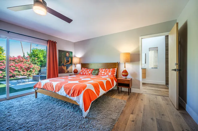 a living room with patio furniture and a potted plant