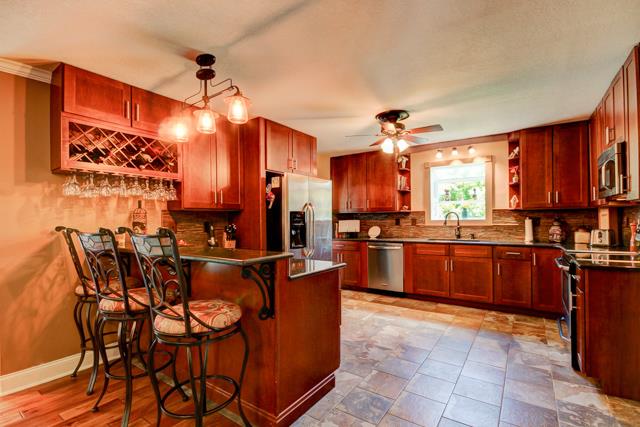 486 Cambridge Road Clarksville, TN 37043 - Photo 7 of 19 Breakfast bar and wineglass cabinet in this beautiful kitchen.