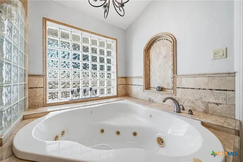 a bathroom with bathtub and window