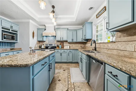 a kitchen with stainless steel appliances granite countertop a sink stove and cabinets