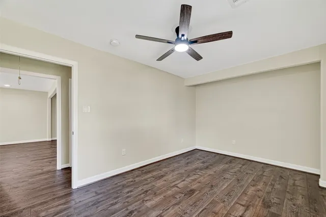 a view of a room with wooden floor and fan