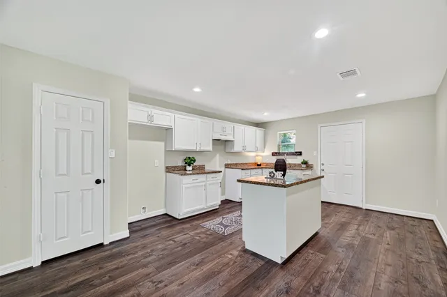 a kitchen with a sink and wooden floor