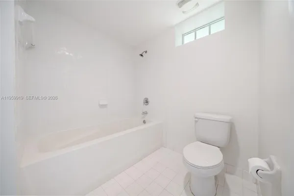 a bathroom with a white toilet and bathtub