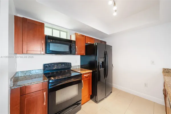 a kitchen with stainless steel appliances granite countertop a stove a refrigerator and a microwave