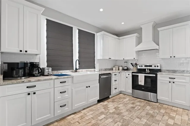 a kitchen with granite countertop a sink stove and refrigerator