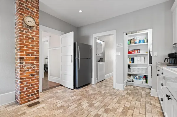 a kitchen with granite countertop a refrigerator stove and cabinets